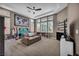 Spacious playroom with large windows and a ceiling fan at 6423 Grayback Dr, North Las Vegas, NV 89084