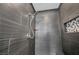 Sleek tiled shower featuring a modern shower head and decorative stone accent niche at 6423 Grayback Dr, North Las Vegas, NV 89084
