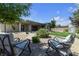 Inviting backyard with comfortable seating area, desert landscaping, and mature trees at 7072 Arabian Ridge St, Las Vegas, NV 89131