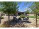 Relaxing backyard seating area surrounded by lush greenery and desert landscaping at 7072 Arabian Ridge St, Las Vegas, NV 89131