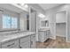 Bright bathroom with dual vanities featuring stone countertops and wood-look tile floors at 7072 Arabian Ridge St, Las Vegas, NV 89131