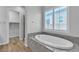 Contemporary bathtub with stone surround and window with shutter-style blinds at 7072 Arabian Ridge St, Las Vegas, NV 89131