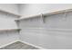 Walk-in closet with wood-look floors and wooden shelving for ample storage at 7072 Arabian Ridge St, Las Vegas, NV 89131