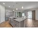 Bright, open kitchen featuring a large island, stainless steel appliances, and wood-style tile flooring at 7072 Arabian Ridge St, Las Vegas, NV 89131
