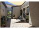 Private outdoor patio with pavers, shaded area, and an iron gate to the backyard at 7072 Arabian Ridge St, Las Vegas, NV 89131