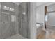 Modern shower with gray stone and glass door, adjacent to a soaking tub at 7072 Arabian Ridge St, Las Vegas, NV 89131