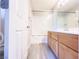 Bright bathroom featuring a tub with glass enclosure and a wood vanity at 7371 Catmint St, Las Vegas, NV 89113