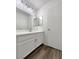 Bathroom vanity with drawers, a large mirror, modern lights, and luxury vinyl plank flooring at 7900 Wood Shadow Ct, Las Vegas, NV 89131
