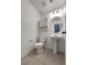 Half-bath featuring tiled floor, pedestal sink, vanity mirror, and modern light fixture at 7900 Wood Shadow Ct, Las Vegas, NV 89131