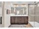This bathroom features double sinks, dark wood cabinets, a large mirror, and a glass-enclosed shower at 8076 Haywood Estate Ave, Las Vegas, NV 89113