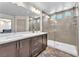 This bathroom features double sinks, dark wood cabinets, a large mirror, and a glass-enclosed shower at 8076 Haywood Estate Ave, Las Vegas, NV 89113