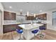 Spacious kitchen with stainless steel appliances, a large island, bar stools, and hardwood floors at 8076 Haywood Estate Ave, Las Vegas, NV 89113
