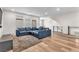 Upstairs living room featuring a comfortable sectional sofa, wood floors, and plenty of natural light at 8076 Haywood Estate Ave, Las Vegas, NV 89113