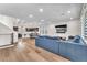 Spacious living room with wood floors, a modern sectional sofa, and a view of the kitchen and dining area at 8076 Haywood Estate Ave, Las Vegas, NV 89113