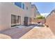 Cozy outdoor patio area with chairs, umbrella, storage unit, and sliding glass door at 8076 Haywood Estate Ave, Las Vegas, NV 89113