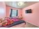 Cozy pink bedroom with a comfortable bed, window with curtains, and a wall-mounted television at 844 Balzar Ave, Las Vegas, NV 89106