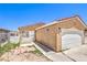 Close-up of a single-story stucco home with a two-car garage, wrought iron details, and minimal landscaping at 844 Balzar Ave, Las Vegas, NV 89106