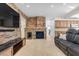Cozy living room featuring a stacked stone fireplace, stone accent wall and comfortable seating at 9417 Grenville Ave, Las Vegas, NV 89134