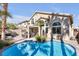 Inviting backyard pool with palm trees, outdoor seating, and attached spa create a private oasis at 9417 Grenville Ave, Las Vegas, NV 89134