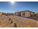 Low-maintenance backyard featuring desert landscaping and a home with a covered patio to enjoy the outdoor space at 1044 Forest Falcon Dr, Henderson, NV 89011