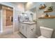 Contemporary bathroom featuring granite countertops, dual sinks, and stylish decor with an adjacent hallway at 1044 Forest Falcon Dr, Henderson, NV 89011