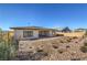 Back exterior of the home featuring desert landscaping, a covered patio, and a private backyard space at 1044 Forest Falcon Dr, Henderson, NV 89011