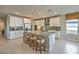 Spacious kitchen with white cabinets, stainless appliances, large island with seating, and tile floors at 1044 Forest Falcon Dr, Henderson, NV 89011