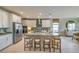 Modern kitchen features stainless steel appliances, white cabinets, large island with seating at 1044 Forest Falcon Dr, Henderson, NV 89011