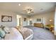Spacious main bedroom featuring modern décor, carpet, fan, and a sitting chair at 1044 Forest Falcon Dr, Henderson, NV 89011