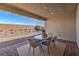 Covered outdoor patio area with a glass-top table and seating for four, overlooking a low-maintenance backyard at 1044 Forest Falcon Dr, Henderson, NV 89011