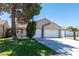 Charming single-story home with a well-manicured lawn, mature tree, and a two-car garage at 1409 Basin Brook Dr, North Las Vegas, NV 89032