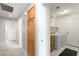 Hallway with carpet leading to laundry room featuring washer, dryer and tile floor at 1409 Basin Brook Dr, North Las Vegas, NV 89032