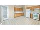 Bright kitchen with white appliances, wood cabinets, and tile flooring, leading to an outdoor entrance at 1409 Basin Brook Dr, North Las Vegas, NV 89032