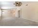 Open living room with neutral carpeting, fan, and large windows, offering ample natural light and space at 1409 Basin Brook Dr, North Las Vegas, NV 89032