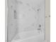 Newly renovated bathroom showcases a white marble-look shower with a built-in toiletry shelf at 1832 N Decatur Blvd # 104, Las Vegas, NV 89108