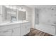 Bright primary bathroom features double sinks and a separate bathtub-shower with marble surround at 1832 N Decatur Blvd # 104, Las Vegas, NV 89108