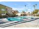 Community pool featuring crystal-clear water, lush landscaping, and stylish architecture with palm trees around at 1832 N Decatur Blvd # 104, Las Vegas, NV 89108