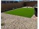 A low-maintenance backyard with artificial grass and rock landscaping is great for outdoor enjoyment at 1885 Vass Springs Pl, North Las Vegas, NV 89084