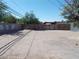 View of the dirt backyard and wood fence, with a large tree at 1912 Statz St, North Las Vegas, NV 89030