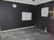 A view of an unfinished basement with cinderblock walls painted black and patched white, with a concrete floor at 1912 Statz St, North Las Vegas, NV 89030