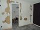 Bedroom view showcasing damaged walls and open bathroom, awaiting a complete remodel and personalization at 1912 Statz St, North Las Vegas, NV 89030