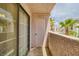 A balcony with a sliding glass door, storage closet, and views of palm trees at 1944 Las Palmas Ln # 174, Laughlin, NV 89029
