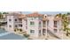 Inviting condo featuring balconies, terracotta tile roof, mature trees, and ample parking spaces at 1944 Las Palmas Ln # 174, Laughlin, NV 89029