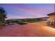 Beautiful backyard with turf and pavers overlooking city lights and desert landscape at sunset at 20 Kittansett Loop, Henderson, NV 89052