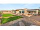 Large backyard with artificial grass, desert landscaping, a covered patio, and ample seating for entertaining at 20 Kittansett Loop, Henderson, NV 89052