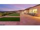 Expansive backyard featuring synthetic turf, stone tile patio, and outdoor seating with beautiful views at 20 Kittansett Loop, Henderson, NV 89052