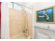 Cozy bathroom featuring a tub and shower combination with beige tile surround, as well as a fun art piece at 20 Kittansett Loop, Henderson, NV 89052