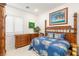 Bright bedroom with tropical-themed decor, a bamboo bed frame, matching dressers, and white tile flooring at 20 Kittansett Loop, Henderson, NV 89052