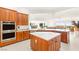 Modern kitchen with a central island, stainless steel appliances, and rich wood cabinetry at 20 Kittansett Loop, Henderson, NV 89052