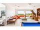 Bright living room featuring a comfortable seating area, pool table, and scenic outdoor views through large windows at 20 Kittansett Loop, Henderson, NV 89052